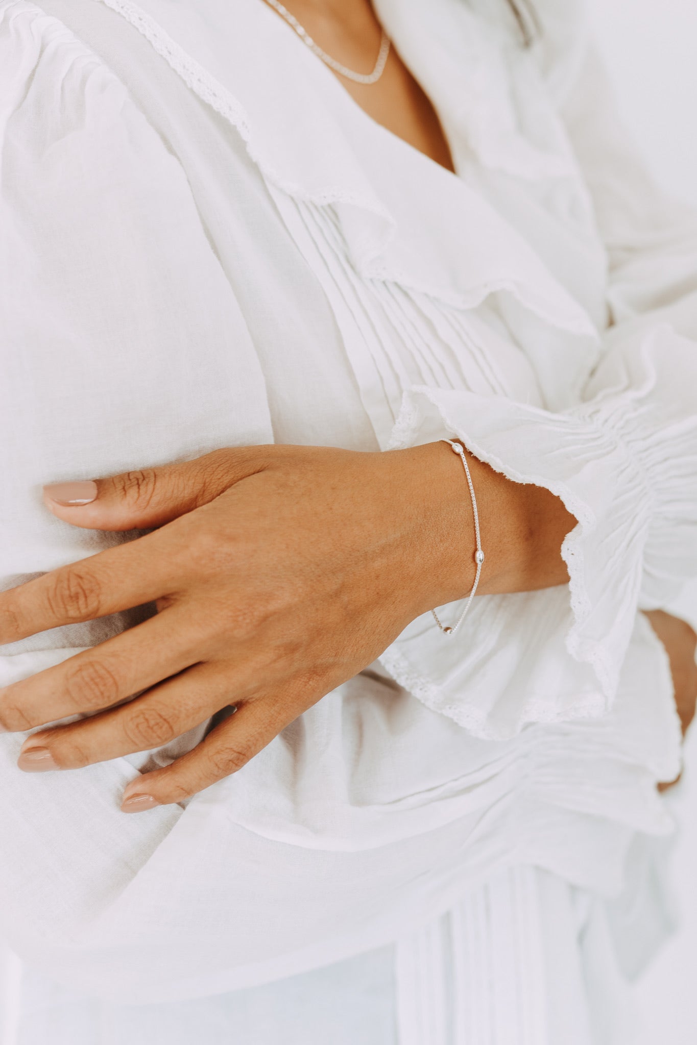 Close-up of a sterling silver floating bead bracelet on wrist.