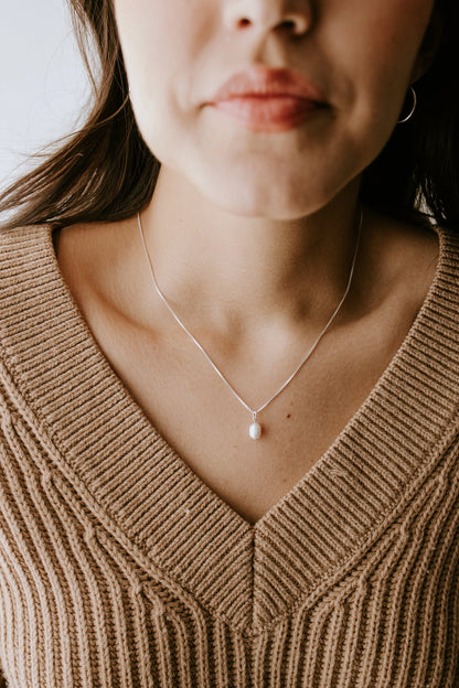 Freshwater pearl necklace in sterling silver styled with cozy neutral knitwear.