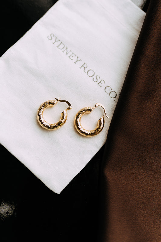 Camellia 18k gold filled textured hoop earrings displayed on Sydney Rose Co. jewelry pouch