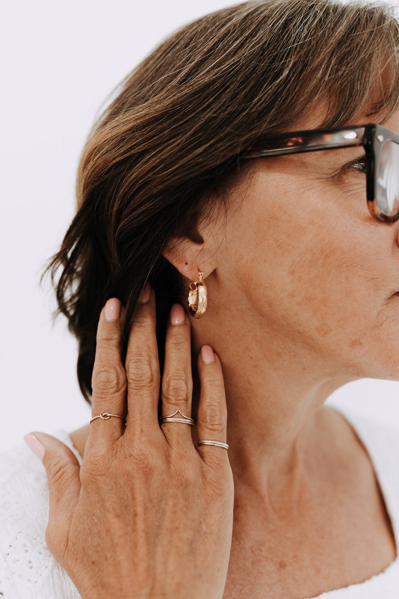 Woman wearing 22mm textured gold filled Camellia hoop earrings