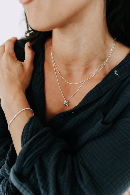 Sterling silver birthstone necklace layered with a satellite chain.