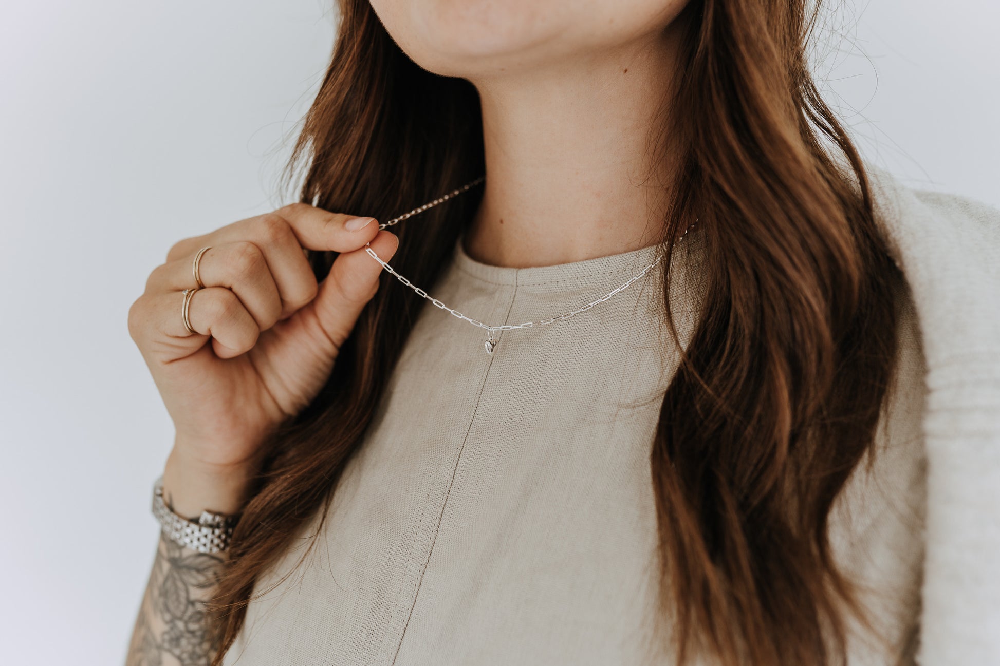 Dainty sterling silver heart pendant necklace layered on a casual everyday outfit