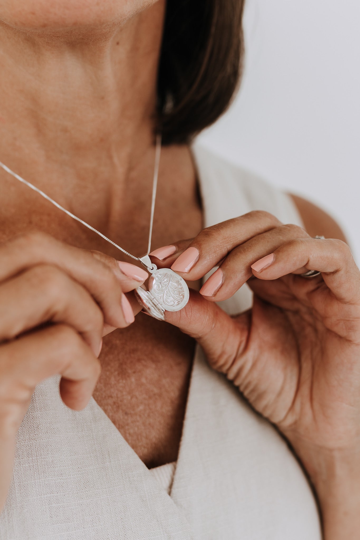 Sterling silver oval locket opened to reveal space for two small photos or keepsakes.