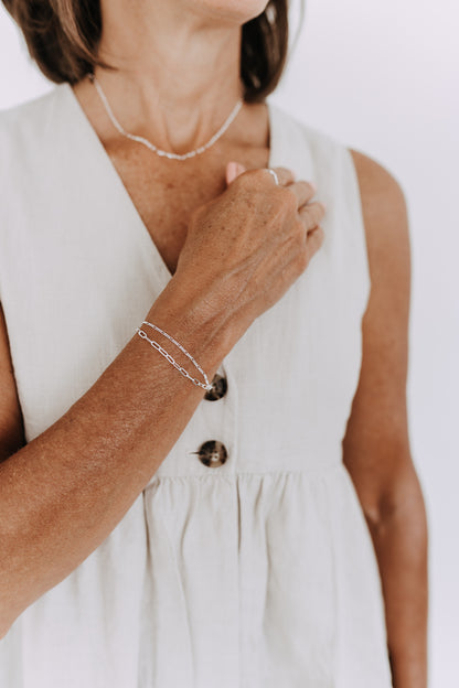 Minimalist sterling silver stack bracelet with joined chain design.