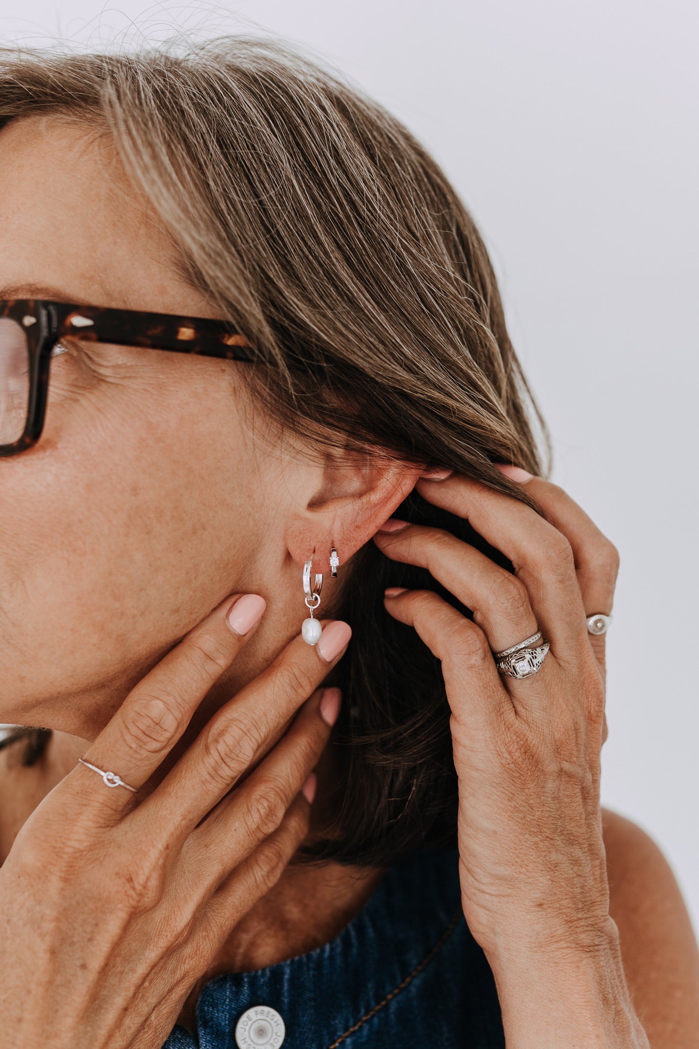 Sterling silver cubic zirconia huggie hoops styled in a minimalist everyday ear stack.