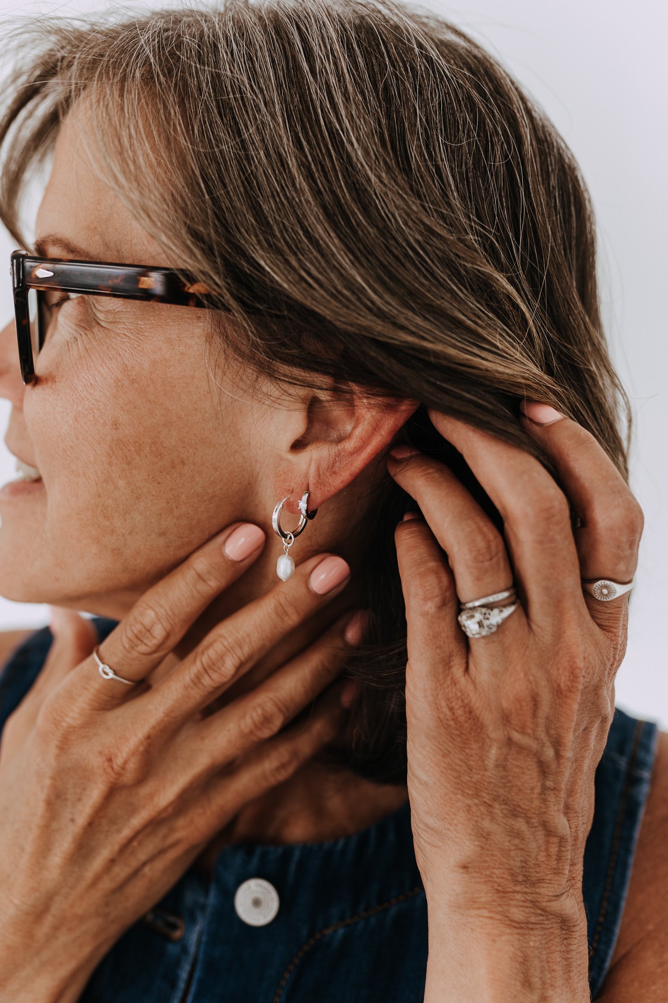 Sterling silver cubic zirconia huggie hoops styled in a minimalist everyday ear stack.