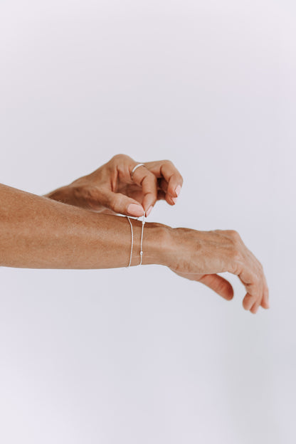 Everyday sterling silver bead bracelet layered with other silver jewelry.