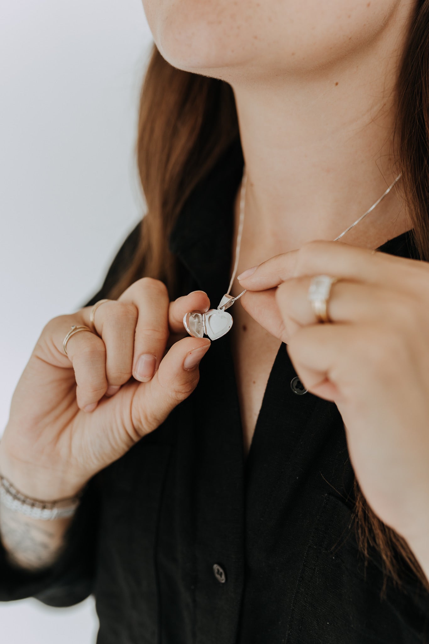 Open sterling silver heart locket showing two compartments for keepsake photos.