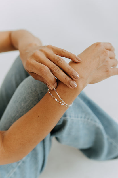 Layered sterling silver bracelet with connected Figaro and Paperclip chains.