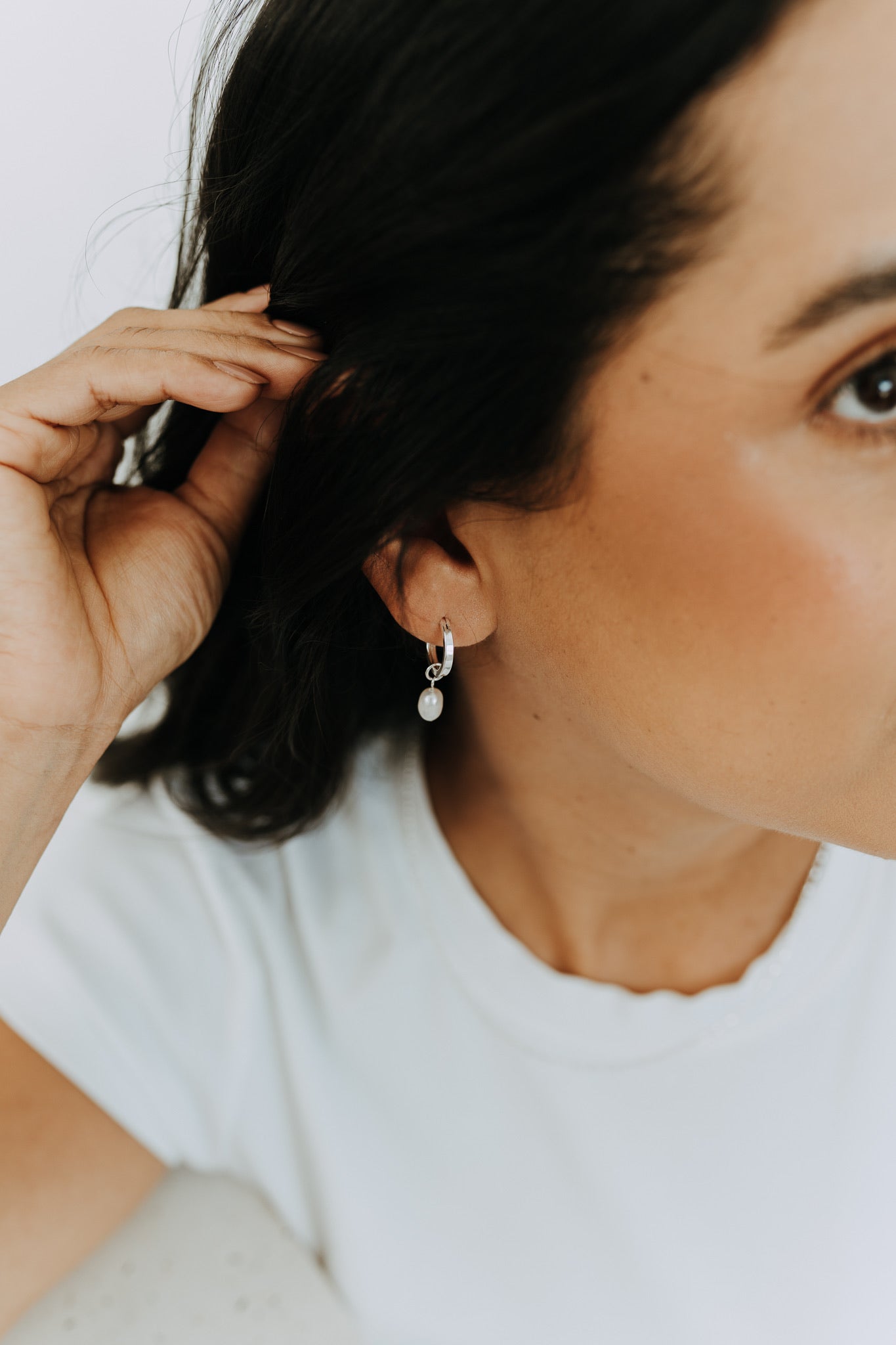 Sterling silver pearl drop hoops styled on model with polished 15mm hoop and freshwater pearl charm.