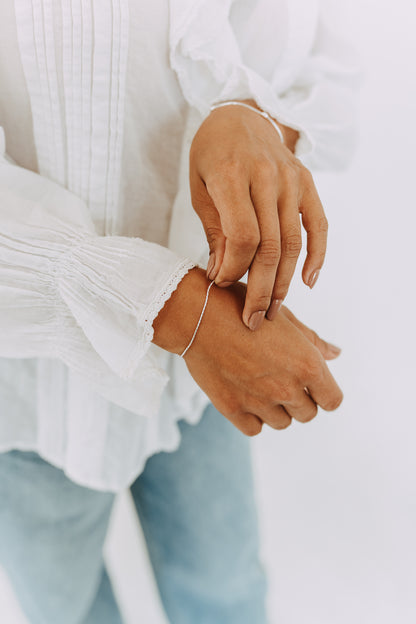 Sterling Silver Shimmer Bracelet with diamond-cut chain worn on wrist with white blouse.