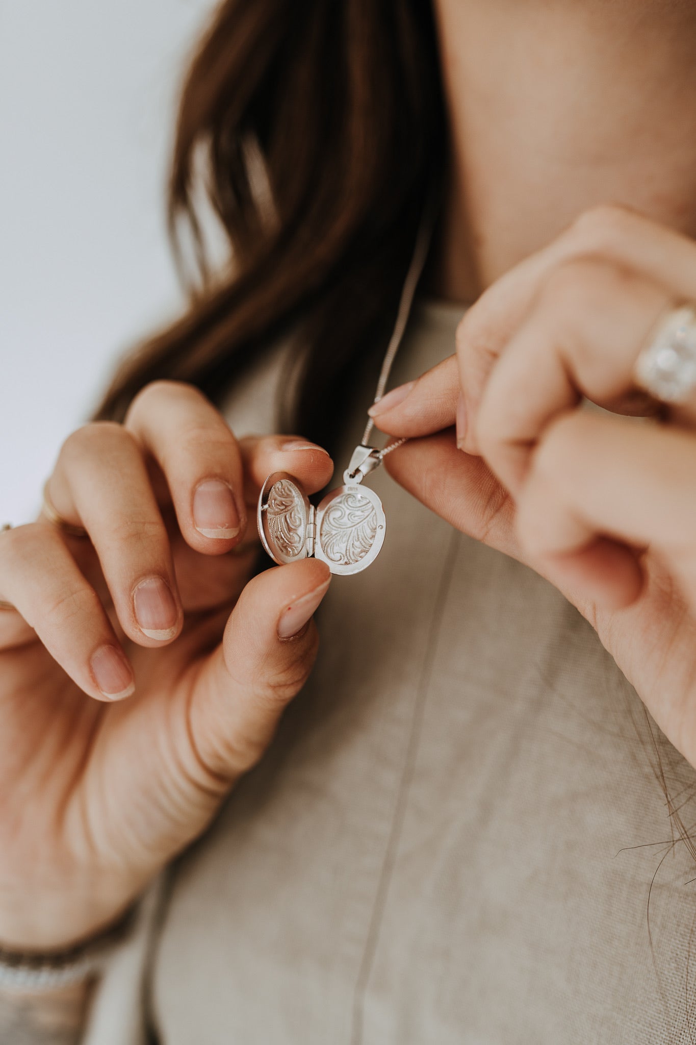 Sterling silver oval locket opened to reveal space for two small photos or keepsakes.