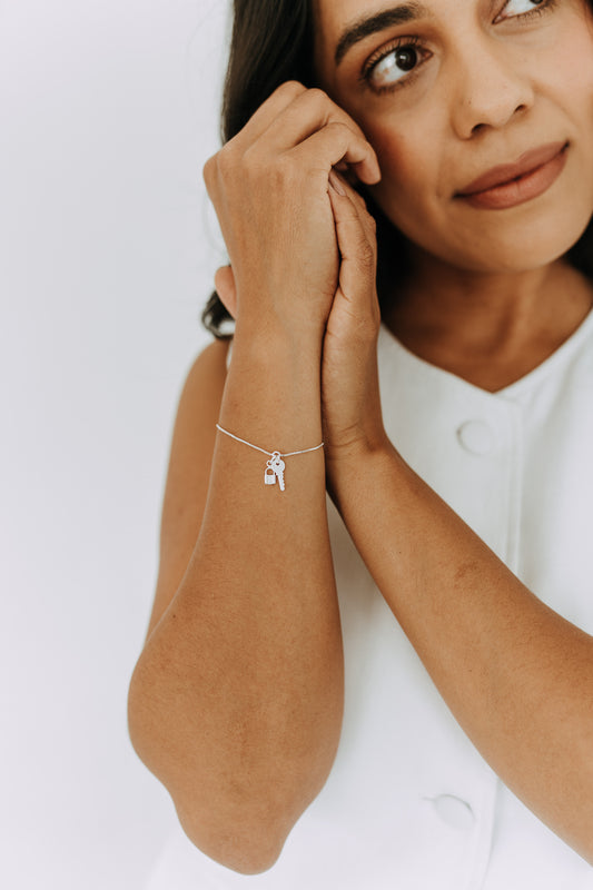 Sterling silver lock and key charm bracelet on model wrist