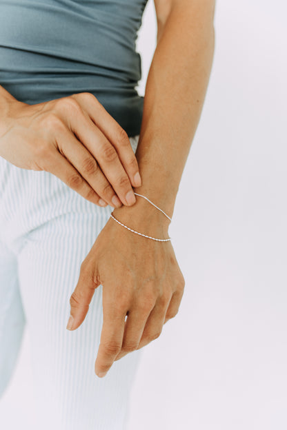 Women's sterling silver double strand bracelet with bead and curb chain details.