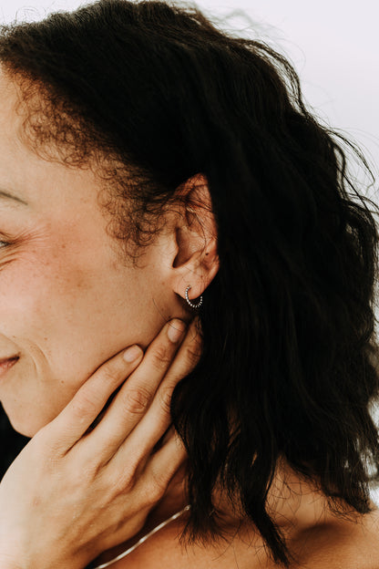 Model wearing Juniper sterling silver beaded huggie hoop earrings in side profile.