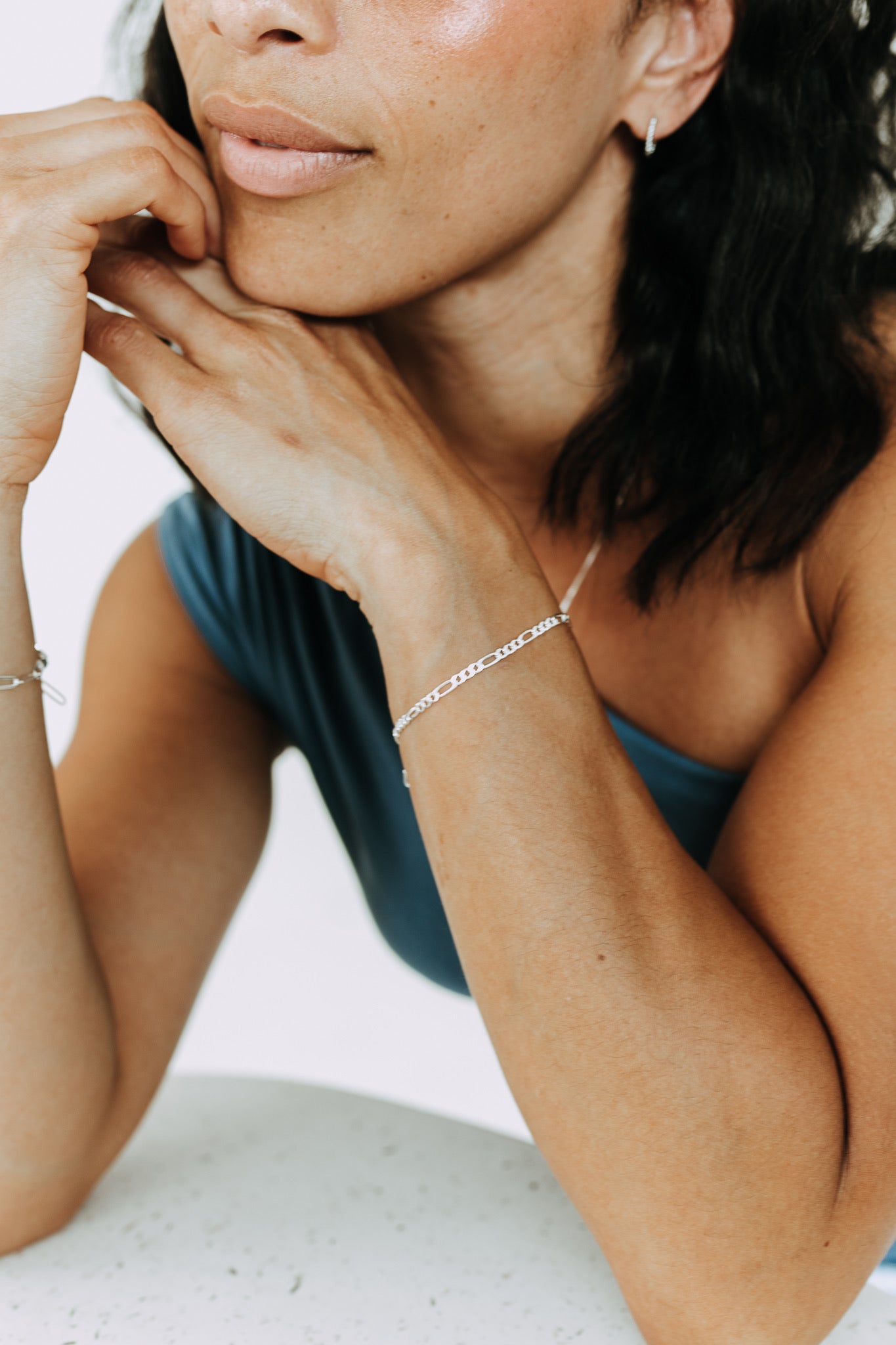 Sterling silver Figaro bracelet styled in a modern layered jewelry look.