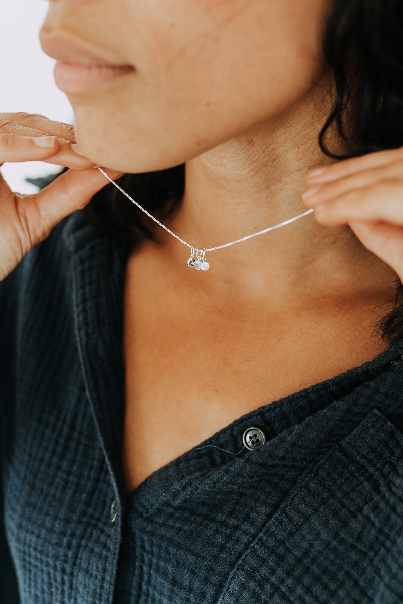 Custom sterling silver birthstone necklace with four round gemstone charms.