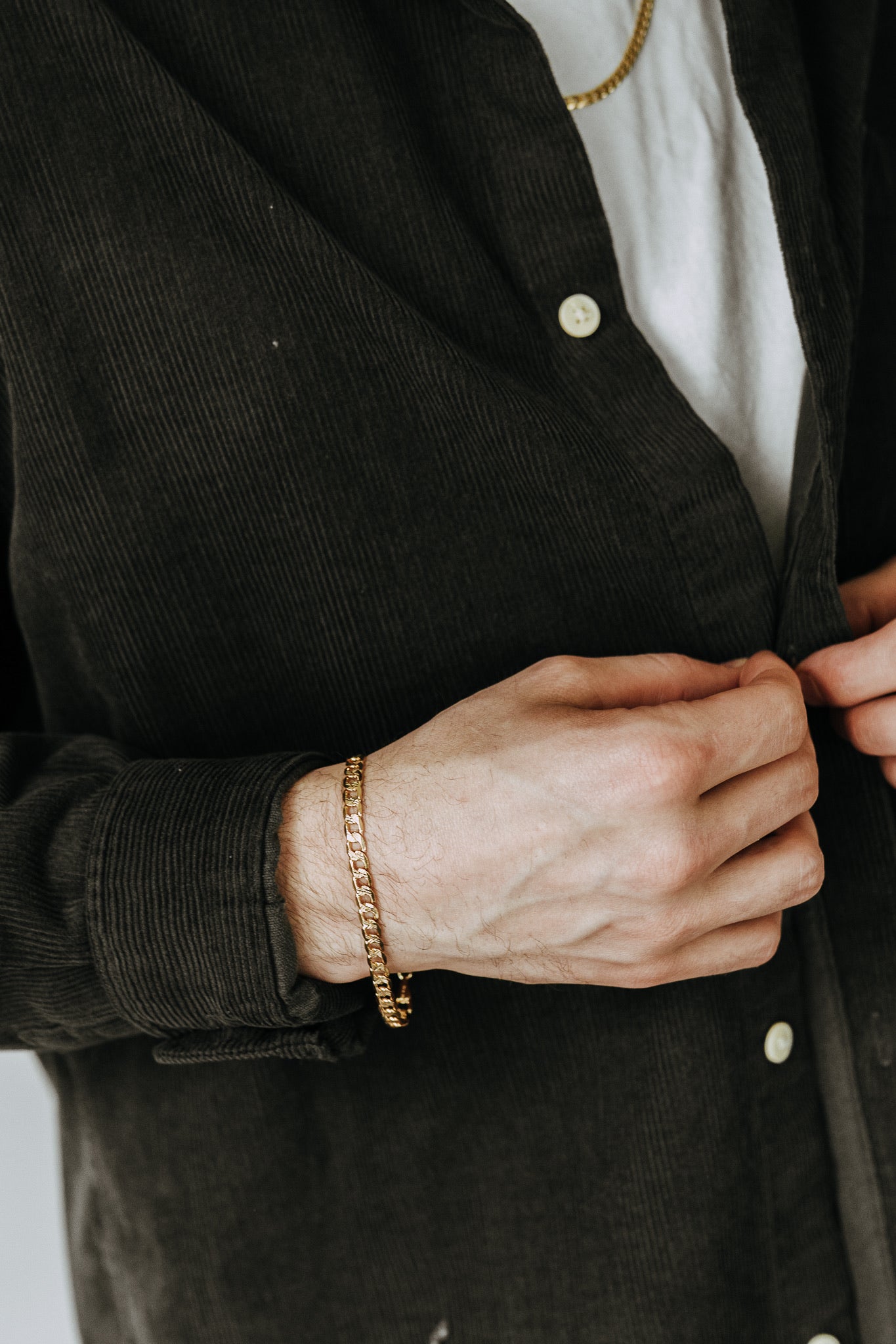 Tarnish-resistant gold curb bracelet for men styled casually with everyday basics