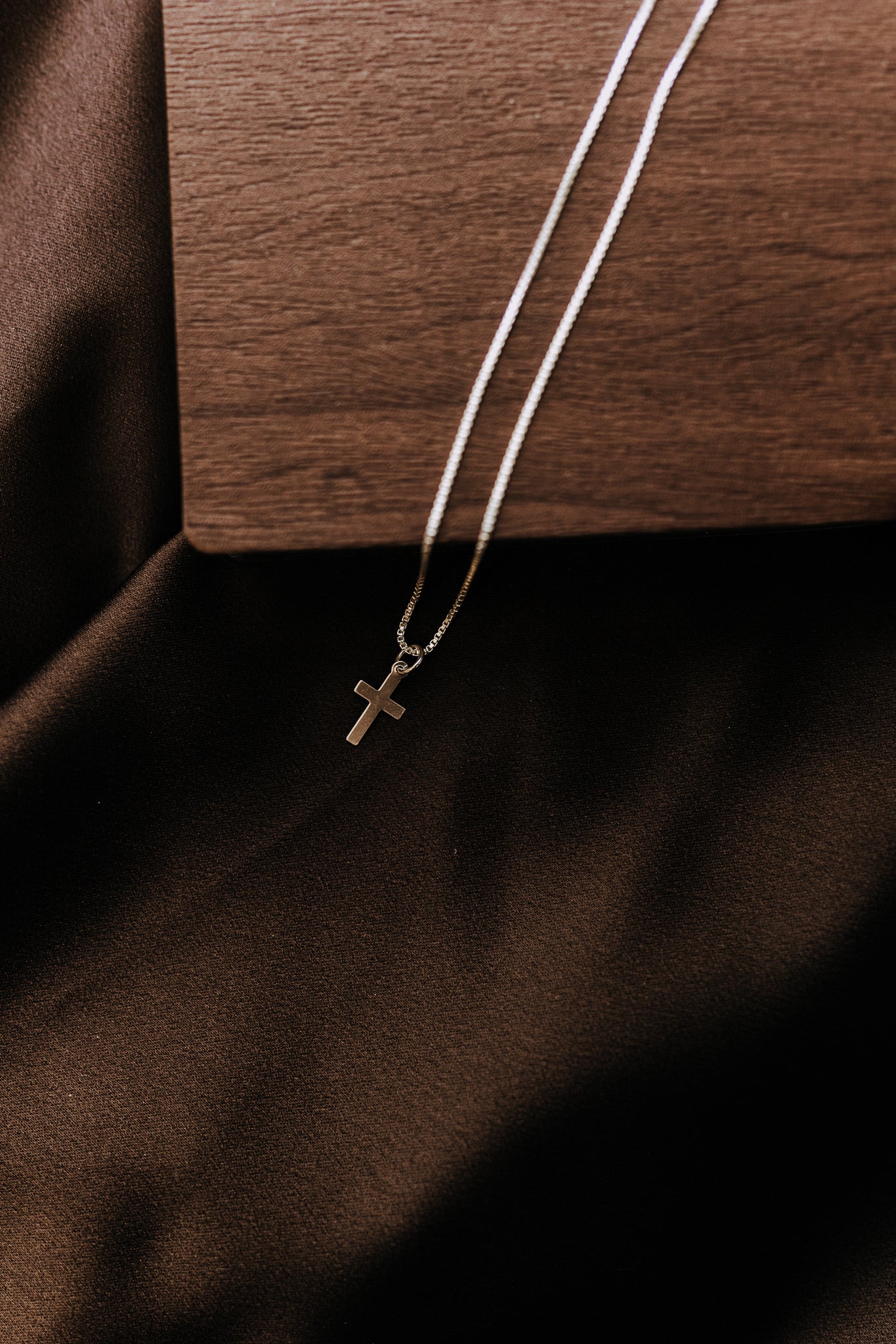 Tiny sterling silver cross necklace for men with sleek simple styling