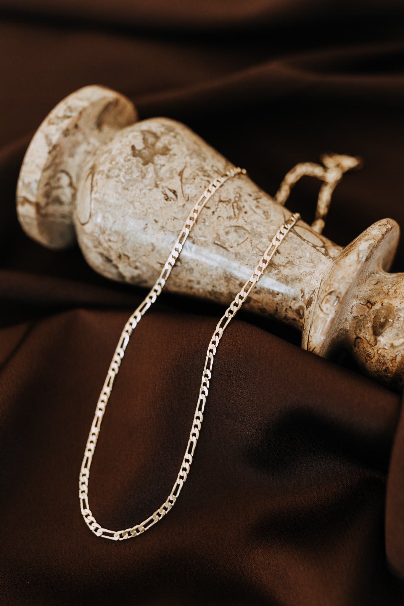 18k gold filled Figaro chain displayed on dark satin fabric