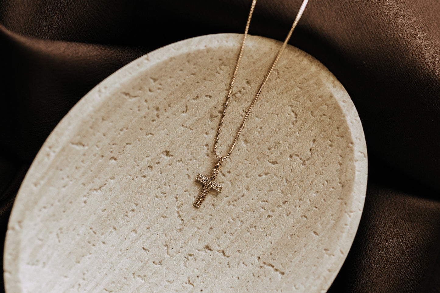 Detailed gold cross pendant necklace on box chain