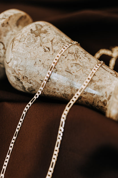 Close-up of 18k gold filled Figaro chain necklace for men with polished flat links