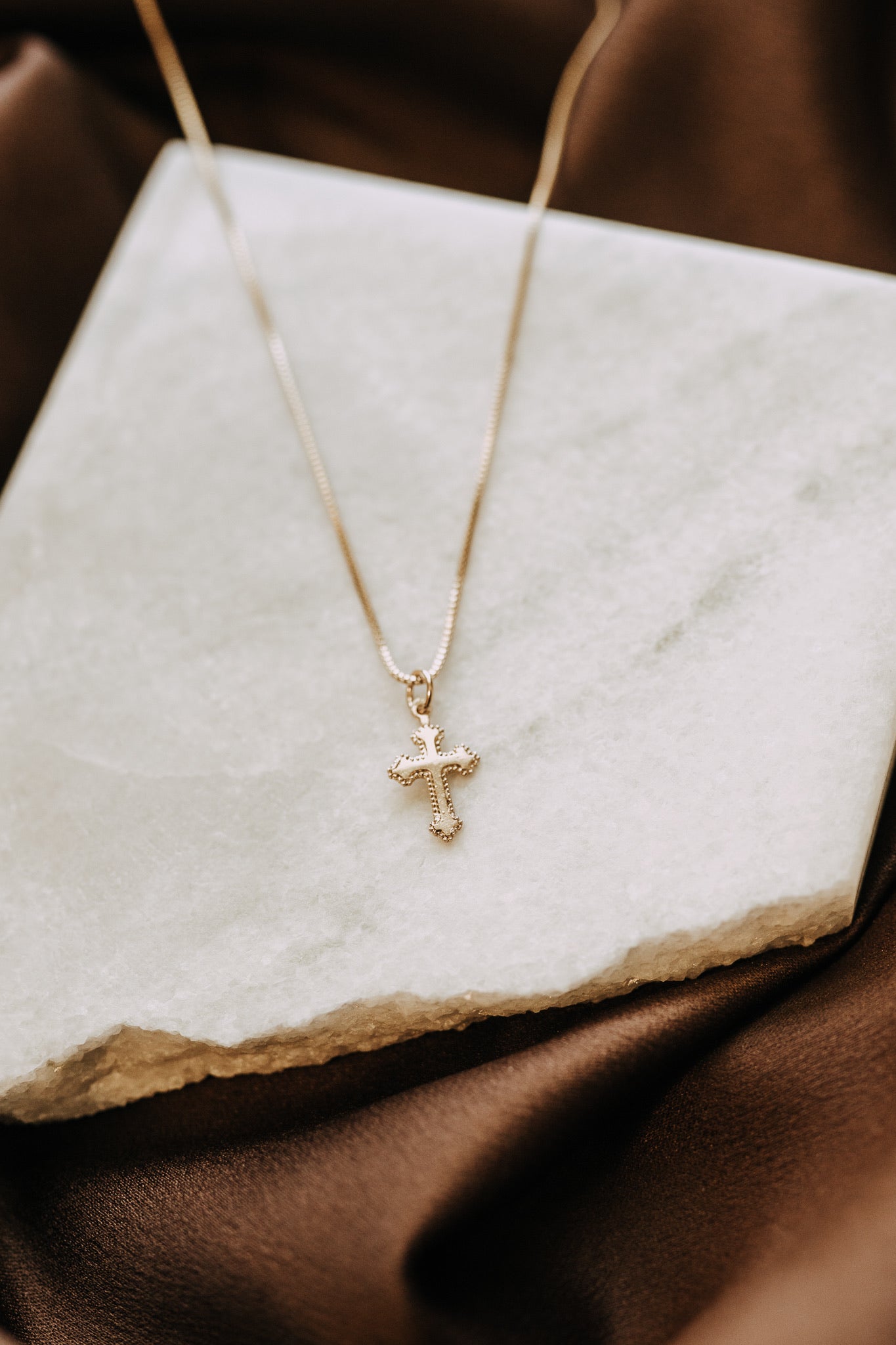 Gold filled cross necklace layered with delicate gold chains