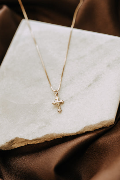Gold filled cross necklace layered with delicate gold chains