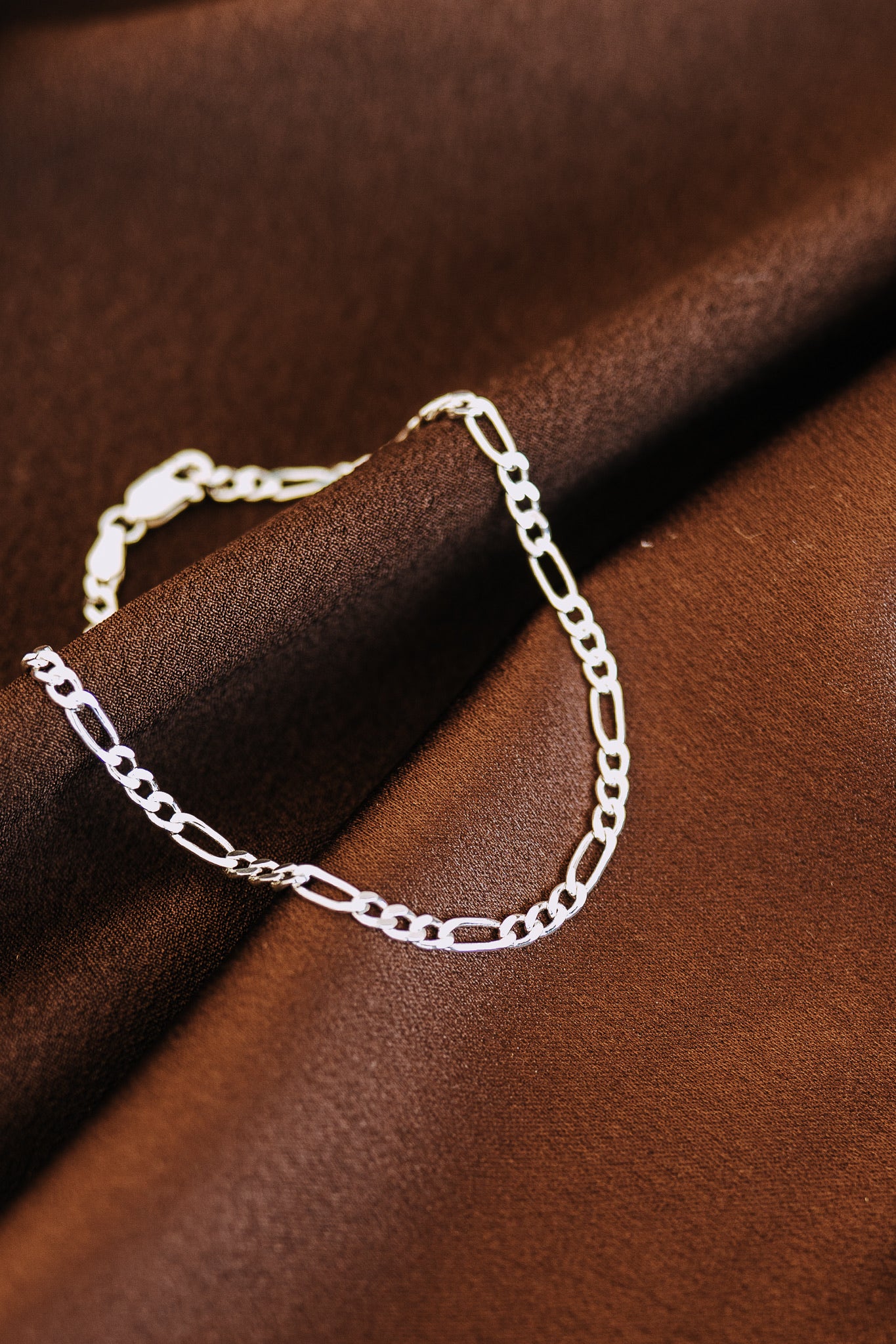 Close-up of men's .925 sterling silver Figaro chain bracelet