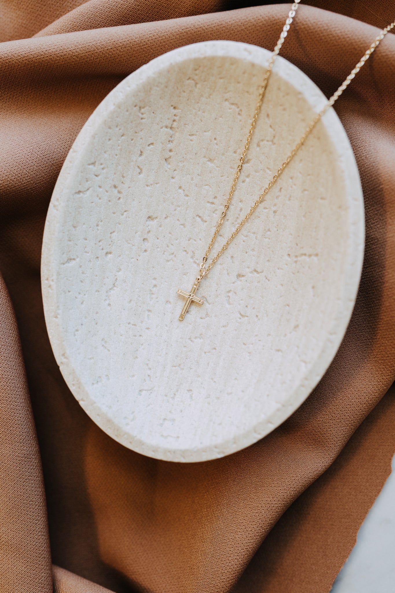 Tiny gold cross necklace on classic cable chain