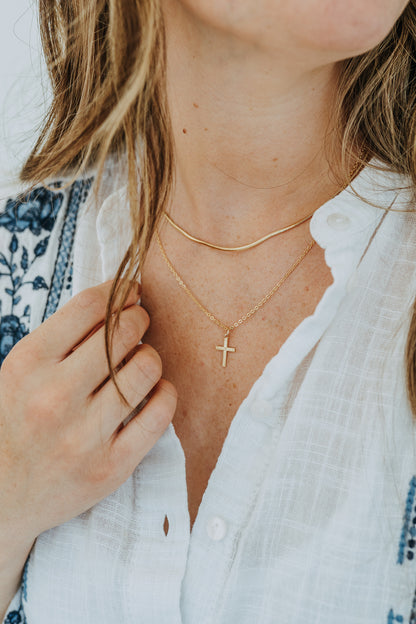 Faith-inspired layered necklace stack with gold cross pendant