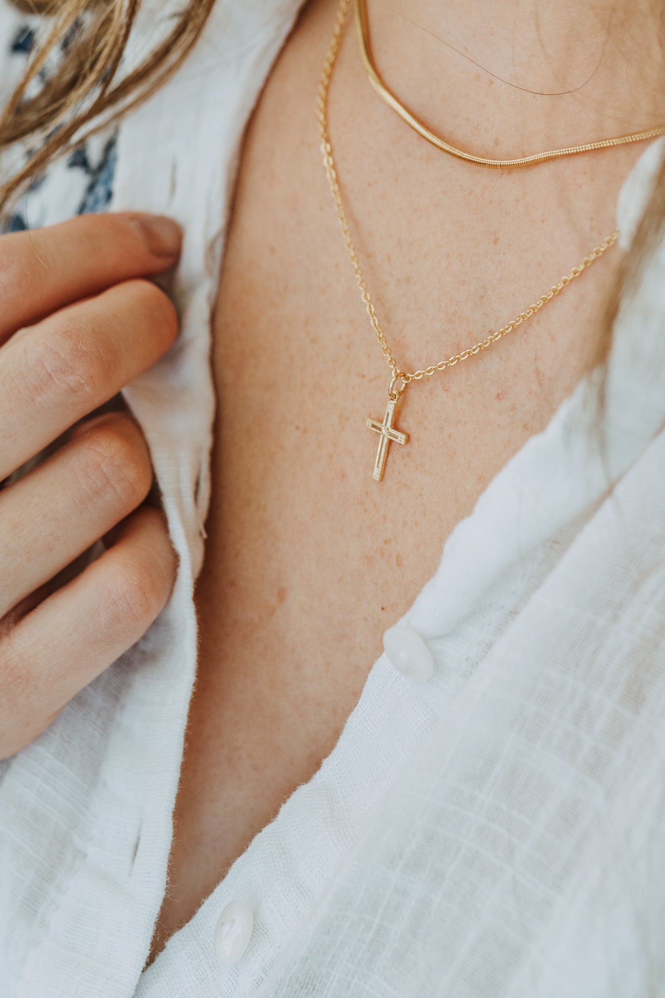 Minimal gold cross pendant necklace styled for everyday wear