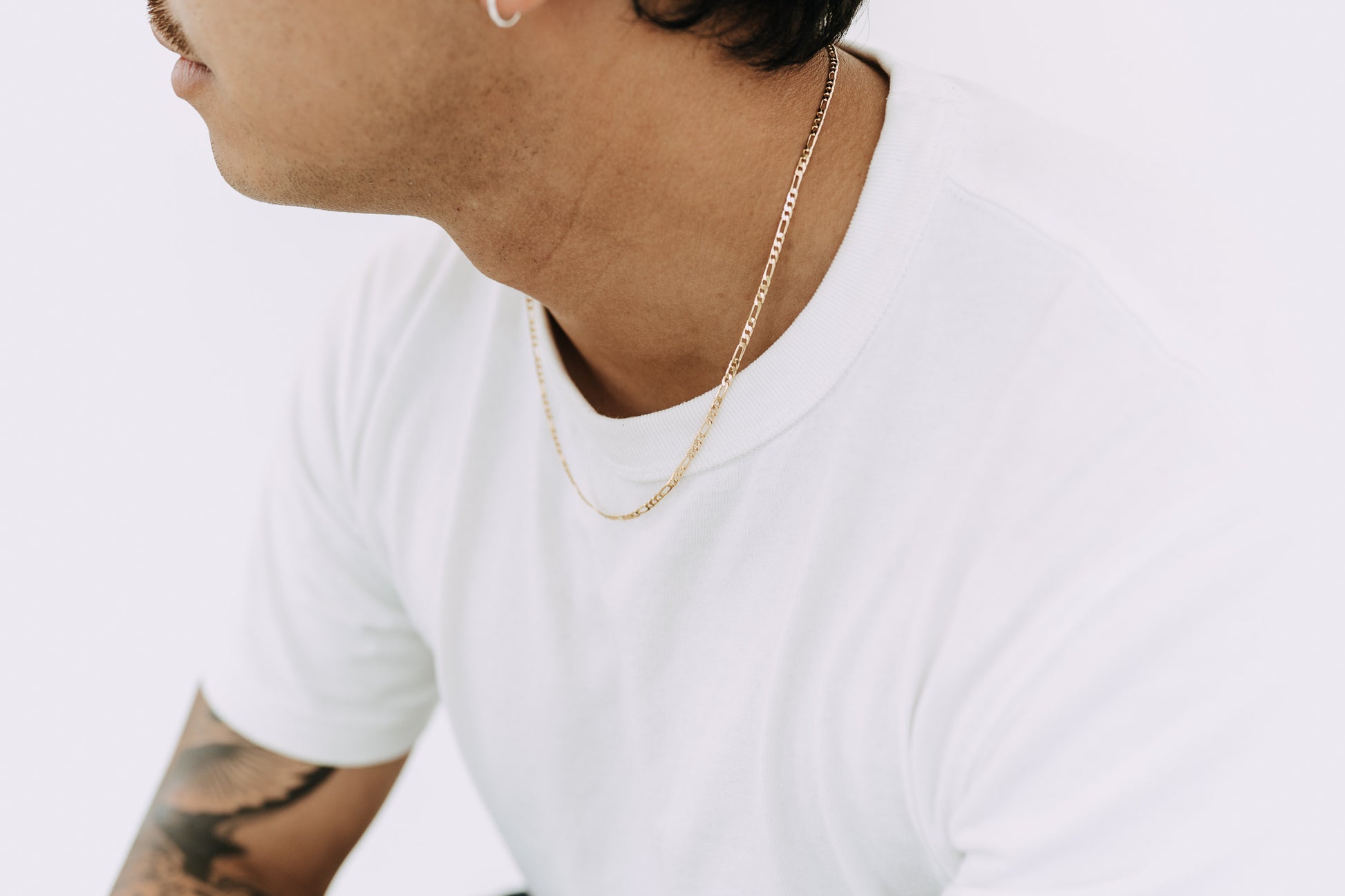 Minimal gold Figaro chain necklace featuring alternating classic link design