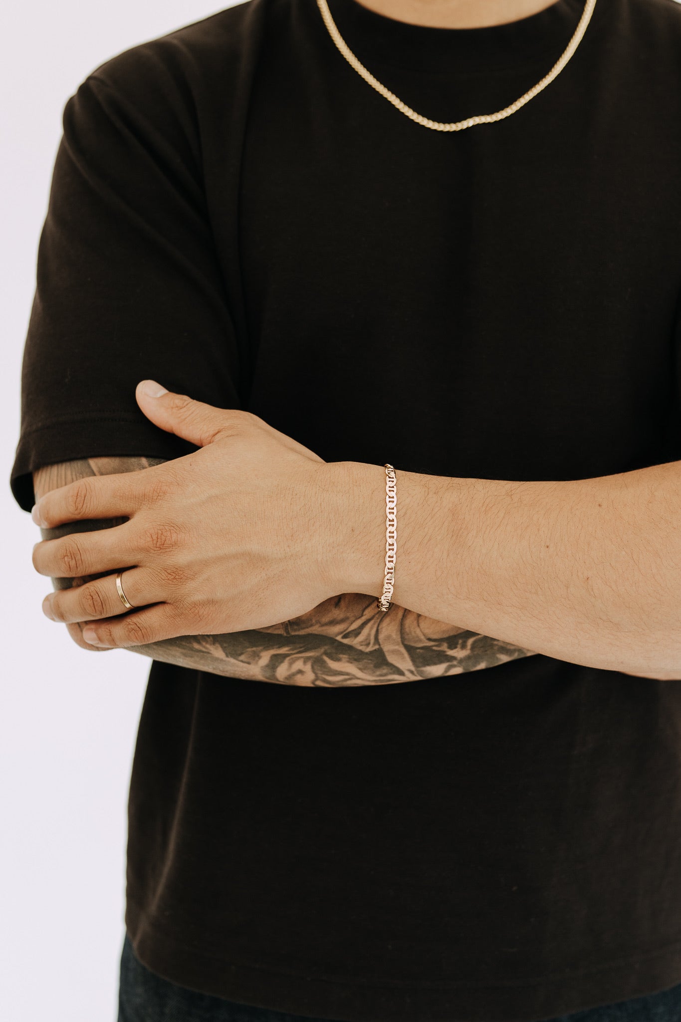 Detailed close-up of gold Roma chain bracelet on wrist with modern masculine styling