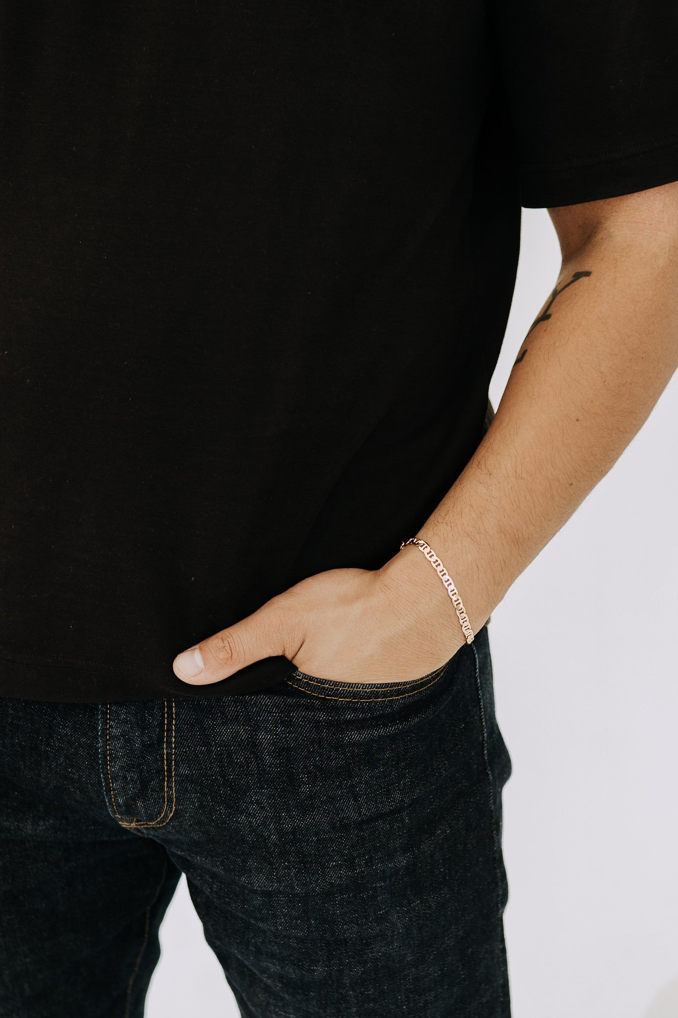 Men’s gold bracelet featuring unique Roma link design paired with casual black basics