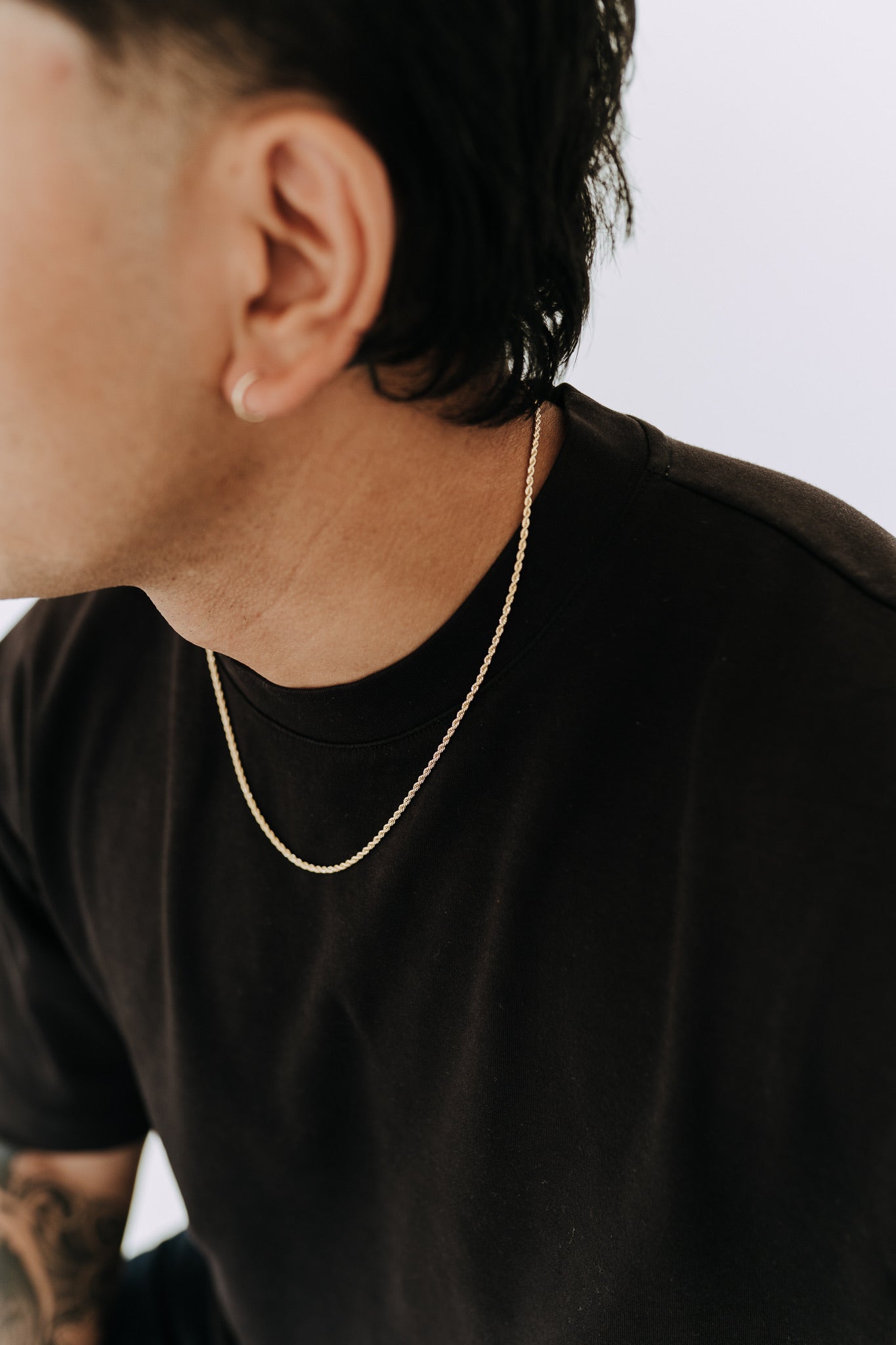 Men’s 2mm rope chain necklace in polished gold styled with a black oversized tee and hoop earring