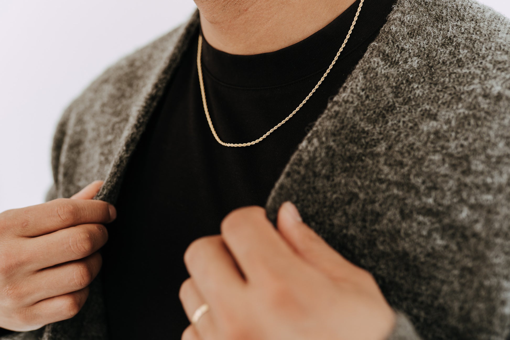 Men’s gold rope necklace paired with textured cardigan and clean minimalist outfit