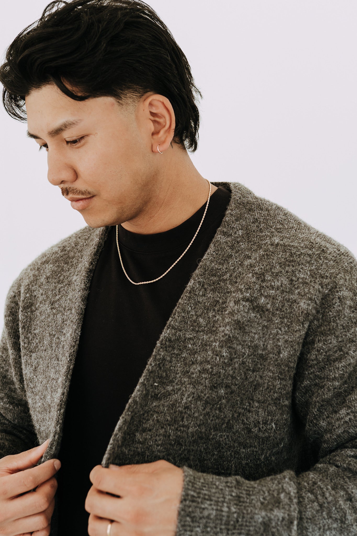 Men’s gold rope necklace paired with textured cardigan and clean minimalist outfit