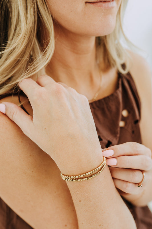 4mm gold filled bead bracelet stacked on wrist with minimal everyday styling