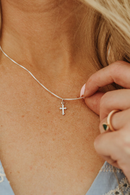 Tiny sterling silver cross pendant necklace close-up