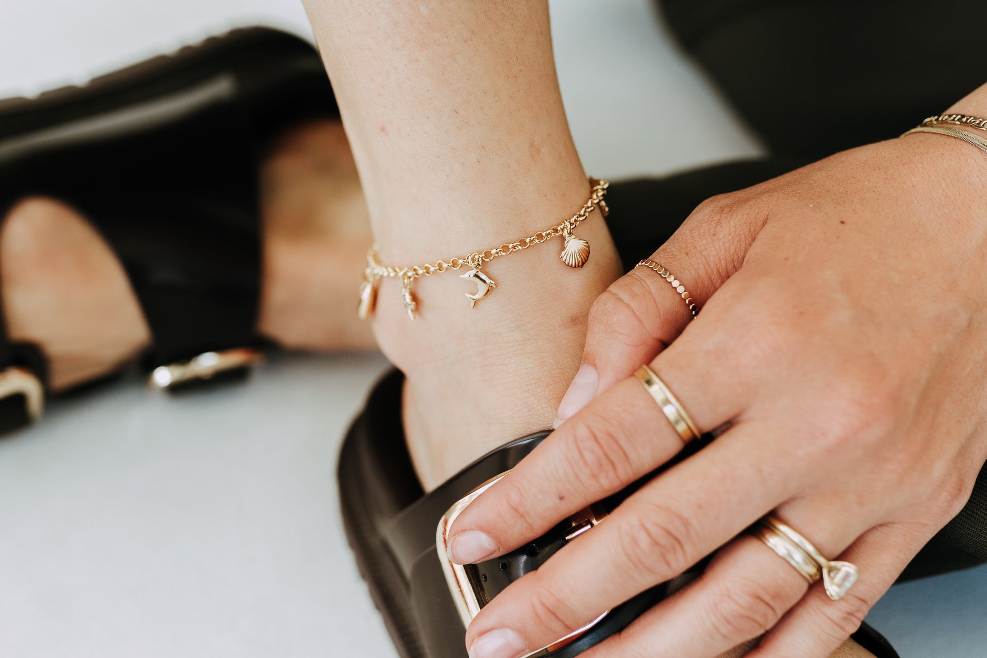 Beach inspired gold anklet styled with chunky black sandals